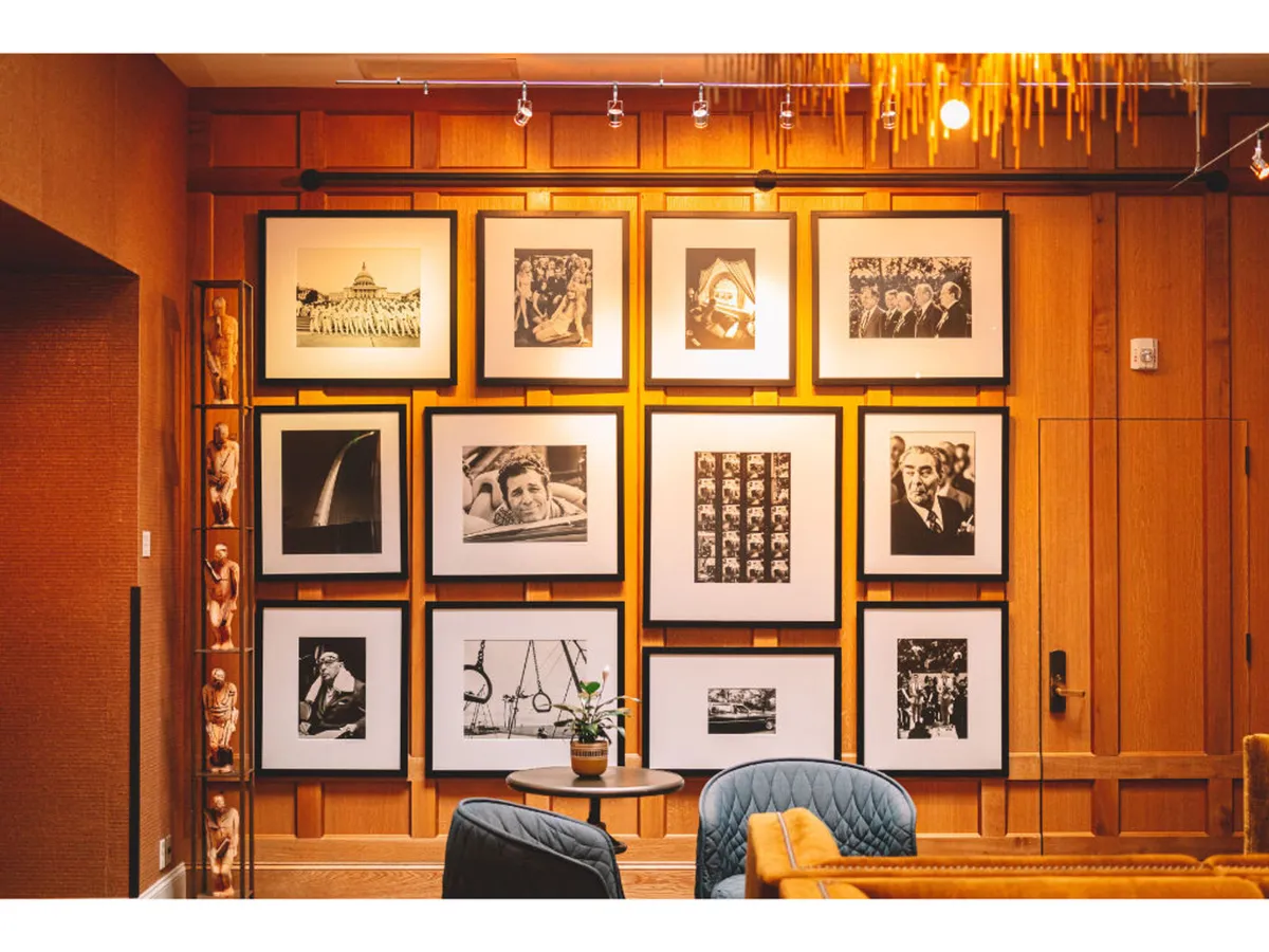 A thoughtfully arranged gallery wall featuring framed black-and-white photography, complemented by minimalistic decor and comfortable seating, creating a space that invites reflection and art appreciation.